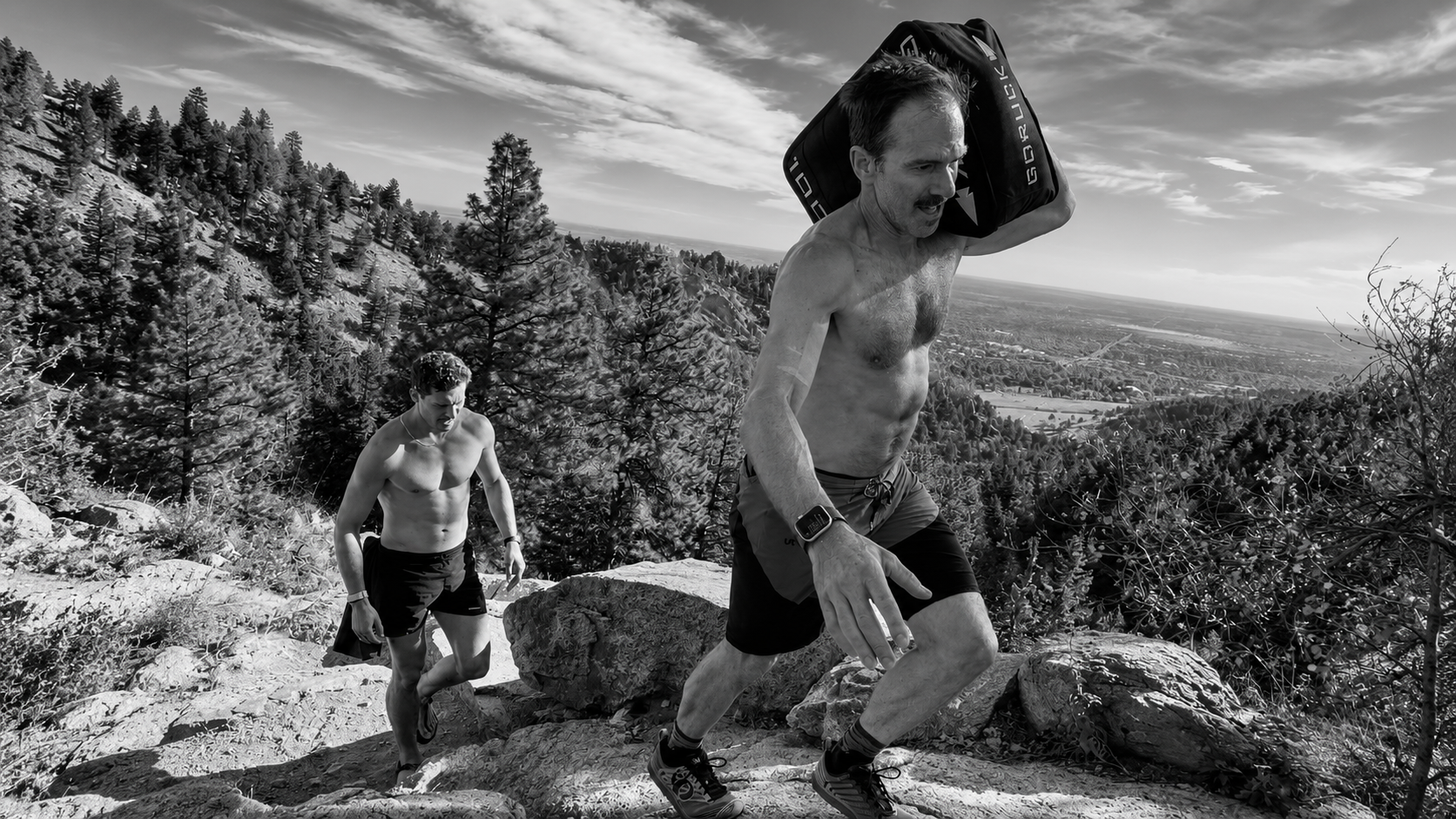 Athlete carrying a sandbag up a mountain trail